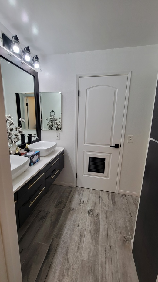 Completed bathroom remodel featuring new vanity, shaker-style door, and luxury ceramic tile flooring.