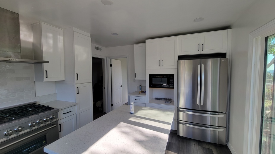 Fully remodeled white kitchen with stainless appliances and modern cabinetry.