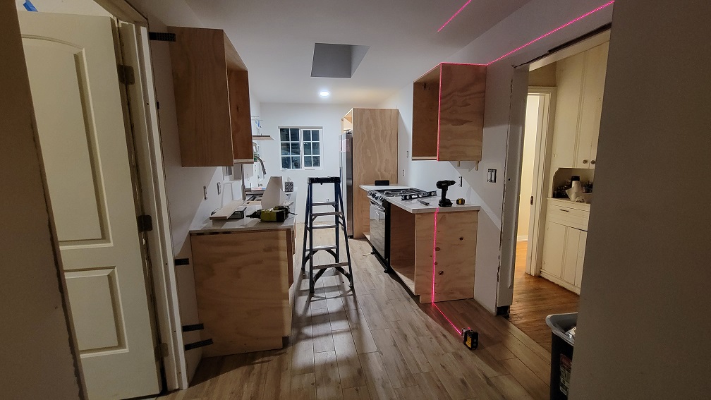 Kitchen remodel in progress with new wood cabinets and layout preparation.